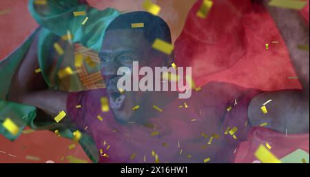 Bild von goldenem Konfetti über jubelnden afroamerikanischen Sportfans, die Flagge von portugal schwenken Stockfoto