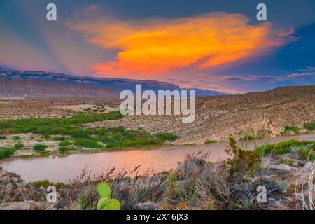 Sonnenuntergang im Fluss Rio Grande in Boquillas Canyon mit im Hintergrund die Berge der Sierra del Carmen Mexiko widerspiegelt. Stockfoto