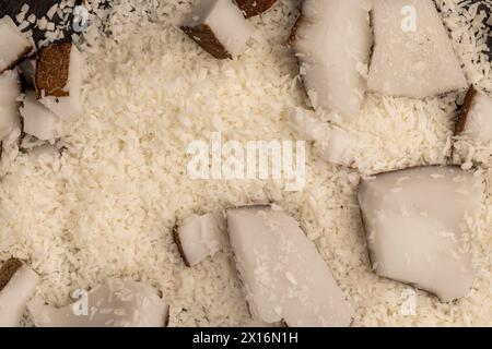 Weißes Kokosnussfleisch und getrocknete Kokosflocken, deren Nahaufnahme bei der Zubereitung von Desserts verwendet wird Stockfoto