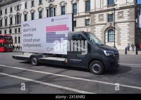 London 15 April 2024 . Ein Van trägt eine Werbung vor dem Parlament mit der Botschaft "Abgeordnete lassen Sie Rauch nicht Ihr Urteilsvermögen trüben" von Cancer Research, in der Politiker für die Gesetzgebung zum Zeitalter des Verkaufs stimmen, um einer rauchfreien Generation zu helfen. Quelle: amer Gazzal/Alamy Live News Stockfoto