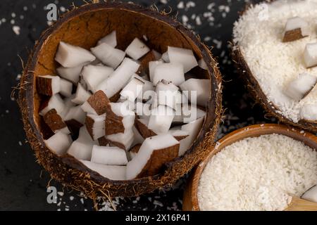 Weißes Kokosnussfleisch und getrocknete Kokosflocken, deren Nahaufnahme bei der Zubereitung von Desserts verwendet wird Stockfoto