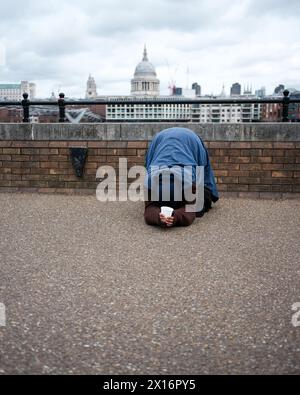Ein Mann, der in London bettelt, am South Bank in der Nähe des St. Pauls Cathederals. Stockfoto