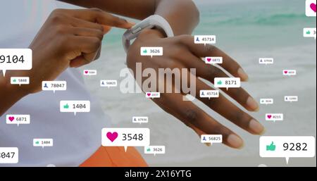 Bild der Benachrichtigungsbalken über der Mitte einer afroamerikanischen Frau, die Smartwatch am Strand benutzt Stockfoto