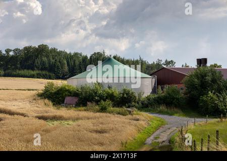 Ein großes, grünes Kuppelzelt sitzt auf einem Feld neben einer Scheune Stockfoto