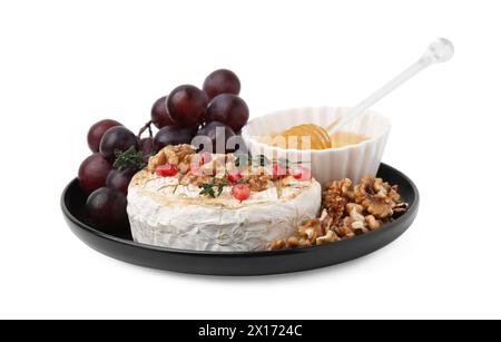 Teller mit leckerem gebackenem Camembert, Honig, Trauben, Walnüssen und Granatapfelkernen isoliert auf weiß Stockfoto