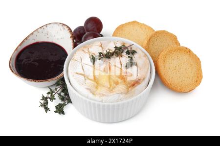 Leckeres gebackenes Camembert, Croutons, Trauben und Marmelade isoliert auf weiß Stockfoto