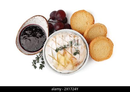 Leckeres gebackenes Camembert, Croutons, Trauben und Marmelade isoliert auf weiß, Blick von oben Stockfoto