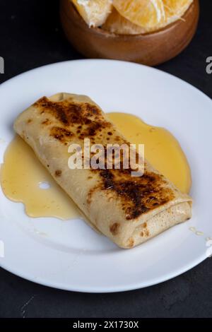 Hausgemachte Milchpfannkuchen mit Honig, natürlicher Bienenhonig und Pfannkuchen gefüllt mit Hüttenkäse mit Zucker Stockfoto