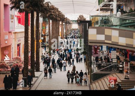 Palmen säumen eine geschäftige Straße in den Avenues, dem größten Einkaufszentrum in Kuwait Stockfoto