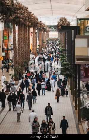 Palmen säumen eine geschäftige Straße in den Avenues, dem größten Einkaufszentrum in Kuwait Stockfoto