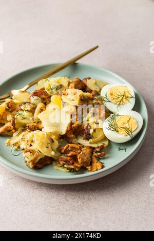 Köstliche herzhafte Abendessen oder Mittagessen, gebratene junge Kartoffeln mit Waldpilzen Chanterelles mit Dill, gekochte Eier, saisonale Speisen Stockfoto