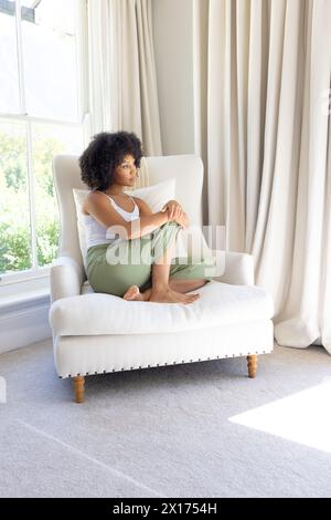 Birassische junge Frau, die zu Hause sitzt und eine Tafel hält Stockfoto