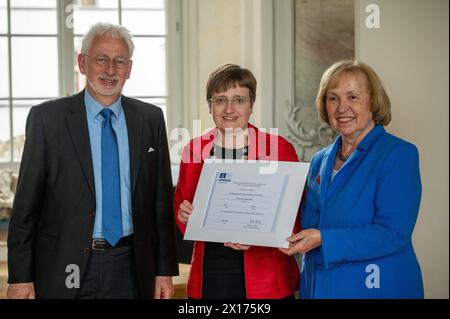 15. April 2024, Rheinland-Pfalz, Trier: Katharina Kaska aus Wien (M) überreicht den UNESCO-Weltdokumentarerbepreis für die Werke der Hofschule Karls des Großen an Maria Böhmer (r), Präsidentin der deutschen UNESCO-Kommission, und Konrad Elmshäuser (l), stellvertretender Vorsitzender des Deutschen Nominierungskomitees für das Weltkulturerbe, nach der Verleihung. Die Ada-Evangelien von Trier sind das Hauptwerk von insgesamt zehn Handschriften der Hofschule Kaiser Karl des Großen, die zum UNESCO-Weltkulturerbe erklärt wurden. Der Präsident der Deutschen UNESCO-Kommission Stockfoto