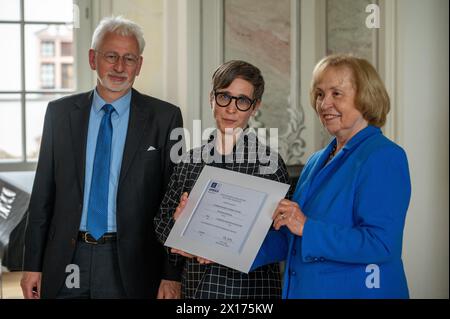 15. April 2024, Rheinland-Pfalz, Trier: Michaela Zöschg (M, London) überreicht den UNESCO-Weltdokumentarerbepreis für die Werke der Hofschule Karls des Großen an Maria Böhmer (r), Präsidentin der deutschen UNESCO-Kommission, und Konrad Elmshäuser (l), stellvertretender Vorsitzender des Deutschen Nominierungskomitees für das Weltkulturerbe, nach der Verleihung. Die Ada-Evangelien von Trier sind das Hauptwerk von insgesamt zehn Handschriften der Hofschule Kaiser Karl des Großen, die zum UNESCO-Weltkulturerbe erklärt wurden. Der Präsident der Deutschen UNESCO-Kommission Stockfoto