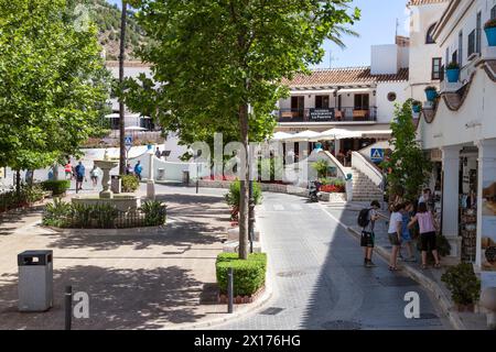 Touristen spazieren auf einem angenehmen Platz umgeben von Geschäften und Restaurants im Bergdorf Mijas, Andalusien; Costa del Sol, Spanien. Stockfoto