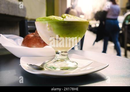 Authentische sizilianische Pistaziengranita, serviert in einem Glas auf dem Bürgersteig eines Cafés in Catanias historischem Zentrum - Essenz der sizilianischen Sommererfrischungen Stockfoto