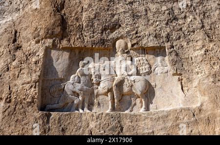 Detaillierte Steinschnitzereien mit historischen Figuren und Ereignissen in Naqsh-e Rostam, ein Zeugnis für die Pracht der alten persischen Architektur im Iran. Stockfoto