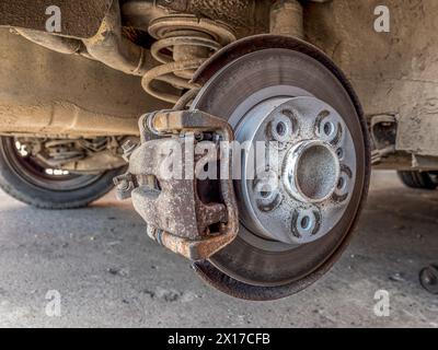 Beifahrerfahrzeug in Hebebühne mit entferntem Hinterreifen und freiliegender Bremsscheibe Stockfoto