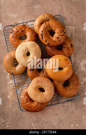 Auswahl an Bagels, die zum Frühstück frisch gebacken wurden, mit Sesam und Zimtrosinen über dem Kopf Stockfoto