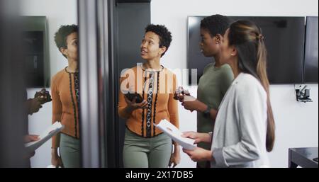 Bild der Datenverarbeitung über verschiedene Geschäftsleute, die im Büro sprechen Stockfoto