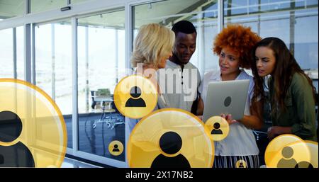 Bild mehrerer Profilsymbole über verschiedenen Kollegen, die Berichte über Notebooks im Büro diskutieren Stockfoto