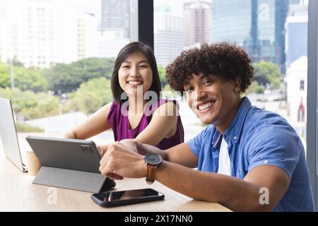 Verschiedene Kollegen arbeiten in einem modernen Geschäftsbüro zusammen und lächeln in die Kamera Stockfoto