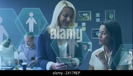Bild von digitalen Symbolen und Datenverarbeitung über verschiedene Geschäftsfrauen mit Tablet Stockfoto
