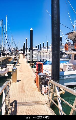 Bootssteg mit Yachten und hohen, schwarzen Anlegestellen im Jachthafen von Exmouth an der Coral Coast in Western Australia Stockfoto