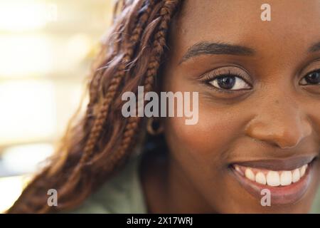 Die junge afroamerikanische Frau mit geflochtenen Haaren lächelt zu Hause Stockfoto