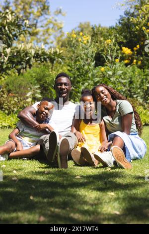 Afroamerikanische Familie sitzt zusammen und lächelt im Garten Stockfoto