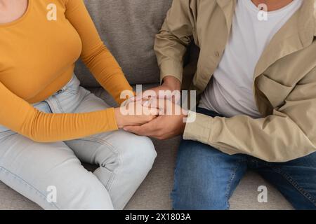Junges Paar, das die Hände bequem hält, abgeschnitten, Ansicht von oben Stockfoto