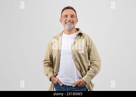Lächelnder Senior-Mann, der mit Händen in den Taschen steht Stockfoto