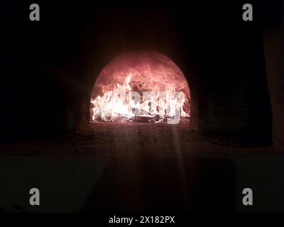 Ein heißes Feuer brennt im Ofen im Dunkeln Stockfoto