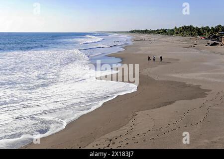 Strand in Poneloya, Las Penitas, Leon, Nicaragua, Mittelamerika, Menschen, die entlang der sanften Meereswellen am weitläufigen Strand in Mittelamerika spazieren Stockfoto