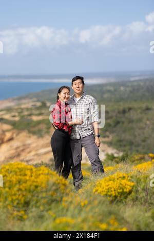 Ein Paar, das auf einem Hügel stand und einen wunderschönen Blick auf das Meer hatte Stockfoto