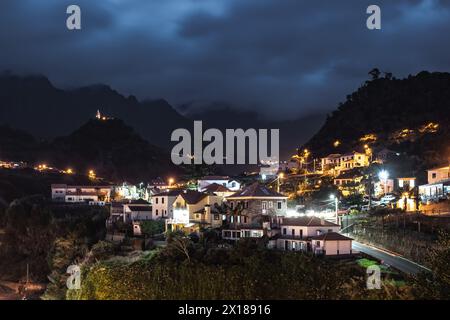 Beschreibung: Die nächtliche Atmosphäre und Straßenlaternen des malerischen Dorfes an der Nordküste in einem grünen, bewachsenen Tal. Sao Vincente, Madeira I Stockfoto