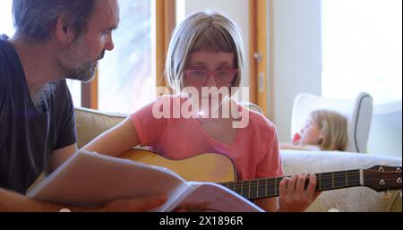 Bild von Licht, das über dem kaukasischen Vater blinkt, der Tochter das Gitarrenspielen lernt Stockfoto