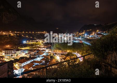 Beschreibung: Nächtliche Atmosphäre, Straßenbeleuchtung und Lichtwege des malerischen Dorfes an der Nordküste in einem grünen, bewachsenen Tal. S Stockfoto