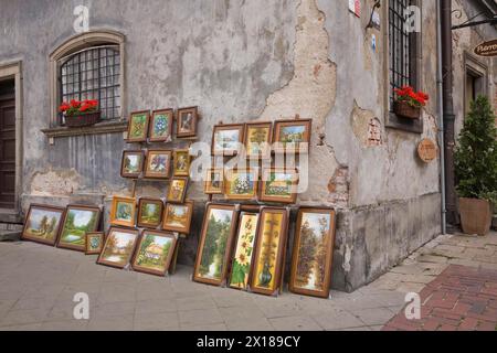 Gerahmte Gemälde an einer alten beschädigten grauen Zementwand auf dem Altstädter Marktplatz in Warschau, Polen Stockfoto