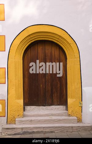 Alte hölzerne Eingangstür mit Haustür und gelber Kontur an der Fassade des Stadtsall-Hotelgebäudes in der mittelalterlichen Stadt Nordlingen, Bayern, Deutschland Stockfoto