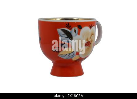 Großer roter Porzellanbecher. Auf dem Becher sind Blumen dargestellt. Isoliert auf weiß Stockfoto