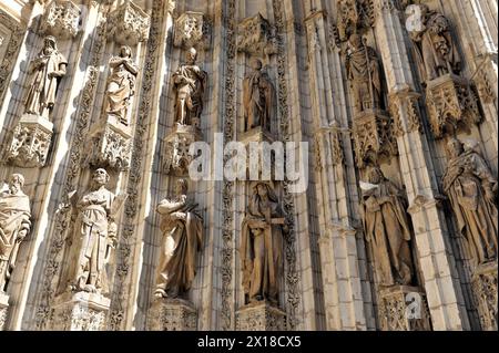 Portal der Kathedrale von Sevilla, Catedral de Santa Maria de la Sede, Sevilla, Eine Reihe von Heiligenskulpturen an der Fassade einer gotischen Kathedrale Stockfoto