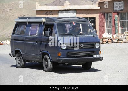 Tichka Pass, Col du Tichka, 2260 m, ein alter Volkswagen Bus fährt auf einer Straße durch die Wüste, Marokko Stockfoto