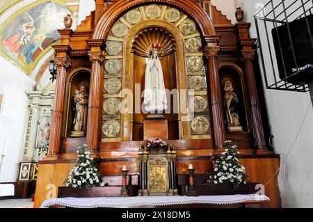 Kirche La Merced, erbaut um 1762, Leon, Nicaragua, ein Altar mit einer Marienstatue, umgeben von Heiligen, Kerzen und Blumen Stockfoto