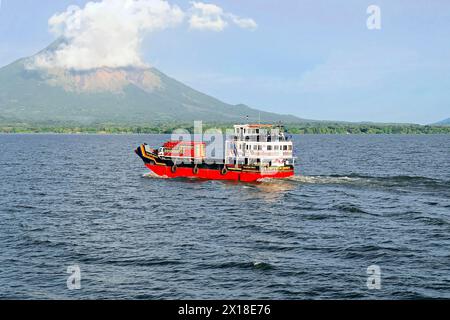 Nicaragua-See, im Hintergrund die Insel Ometepe, farbenfrohe Fähre auf dem See, Transport von Fahrzeugen mit einem Vulkan im Hintergrund und Stockfoto