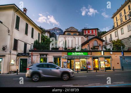 12-172019 Comer See IT Car fährt auf Küstenstraße auf Comer See , beleuchtetes Dorf Tremezzo oder Cadenabbia - Dämmerung auf See Dunkel kommt schnell herein Stockfoto