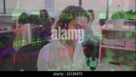 Eine Geschäftsfrau telefoniert in einem geschäftigen Büro Stockfoto