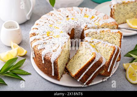 Zitronenmohnkuchen, ganzer Kuchen mit Scheiben Stockfoto