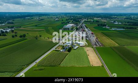 Dieses Bild fängt das Wesen des ländlichen Lebens ein, in dem sich eine kleine Stadt nahtlos in die umliegenden grünen Felder einfügt. Stockfoto