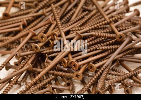 Keramikbeschichtete braune Holzschrauben mit flachem Kopf. Außenschrauben mit Vierkantkopf. Robertson-Deck-Schrauben. Holzschrauben mit grobem Gewinde. Stockfoto